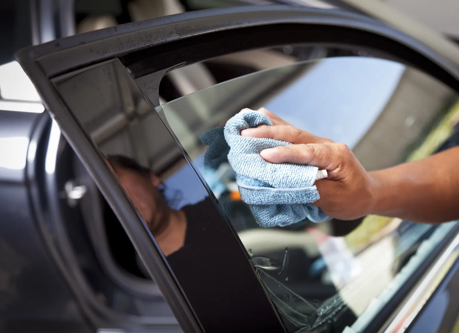 Fahrzeugscheibe wird von innen mit einem Mikrofasertuch gereinigt